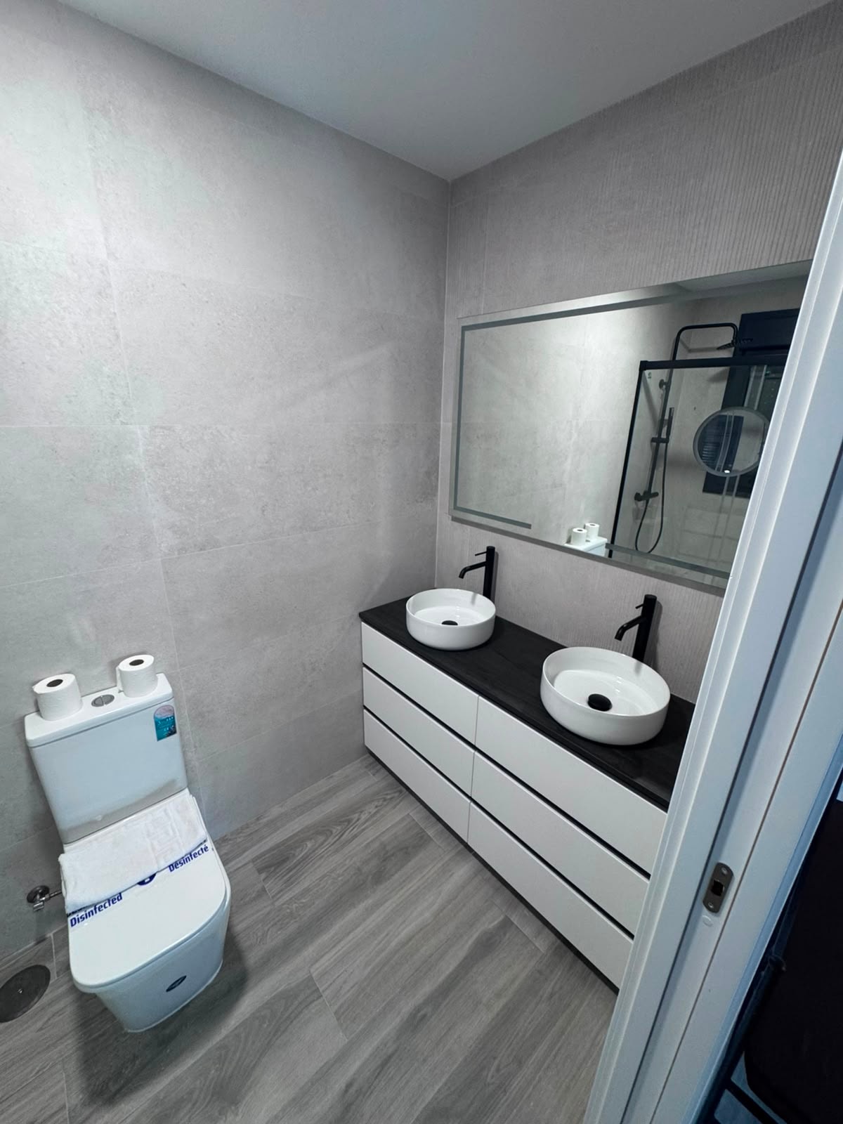 Baño principal con doble lavabo redondo y mueble blanco