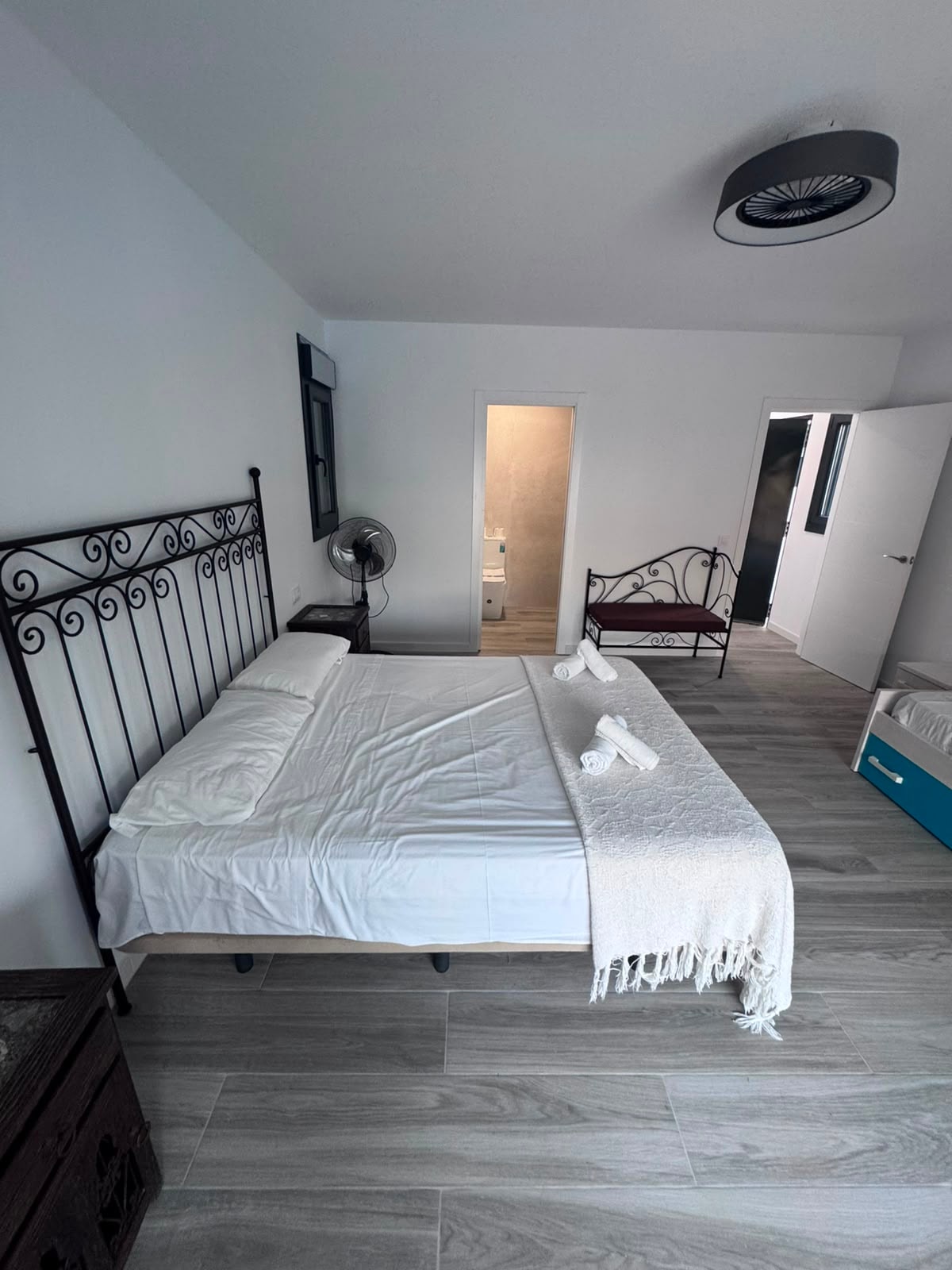 Habitación principal con cama de forja y baño en suite
