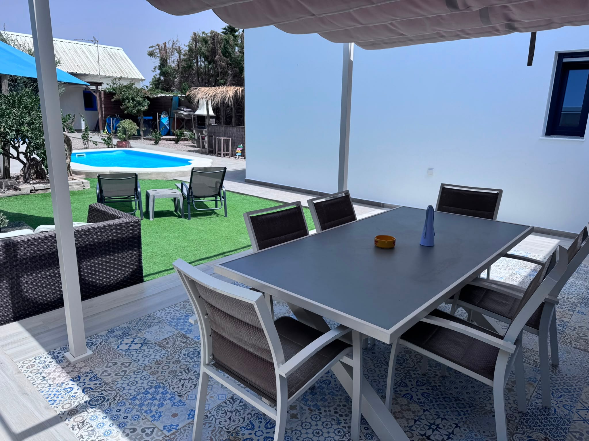 Terraza cubierta con mesa de comedor exterior